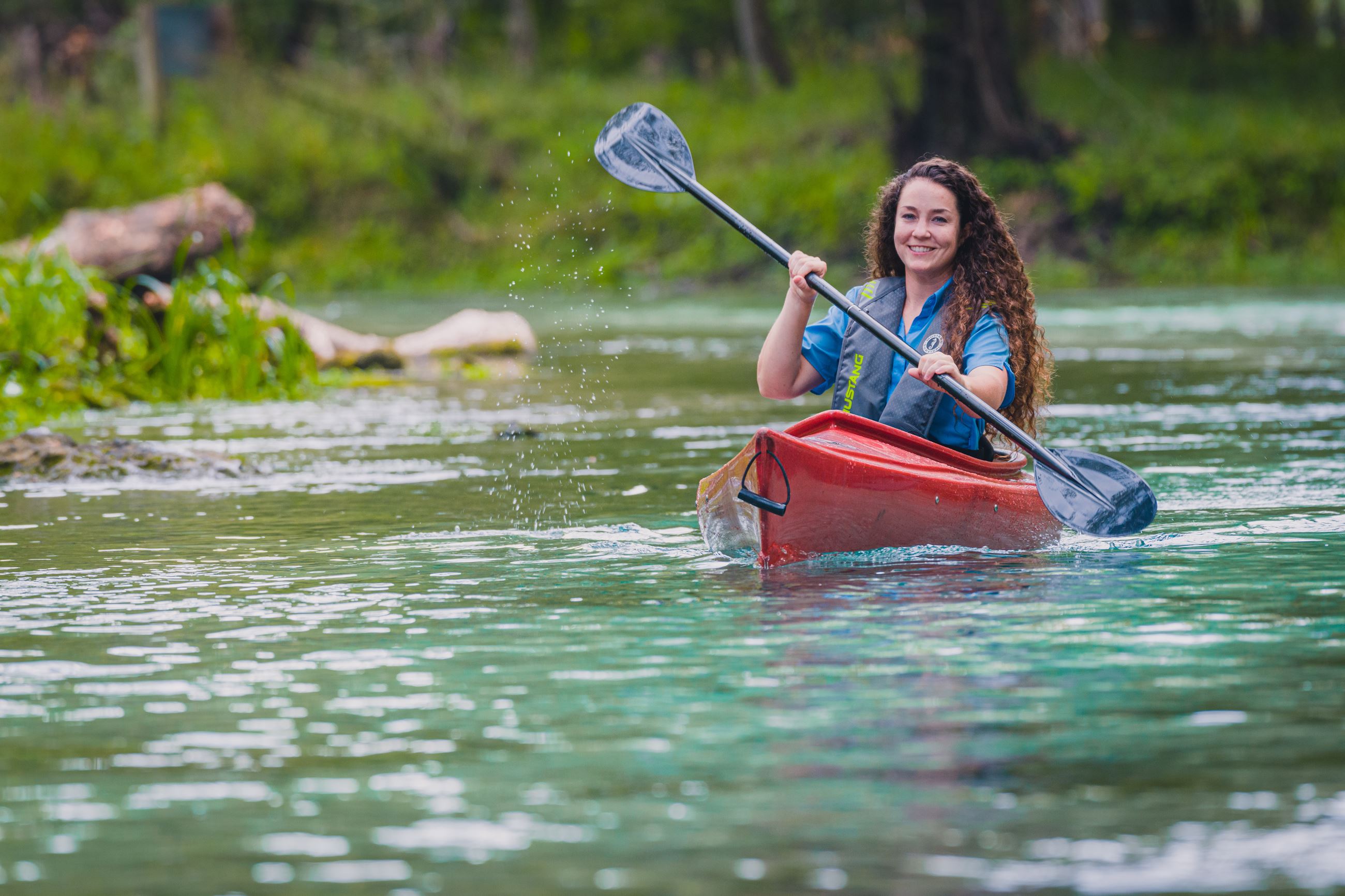 Woman paddling a kayak.
