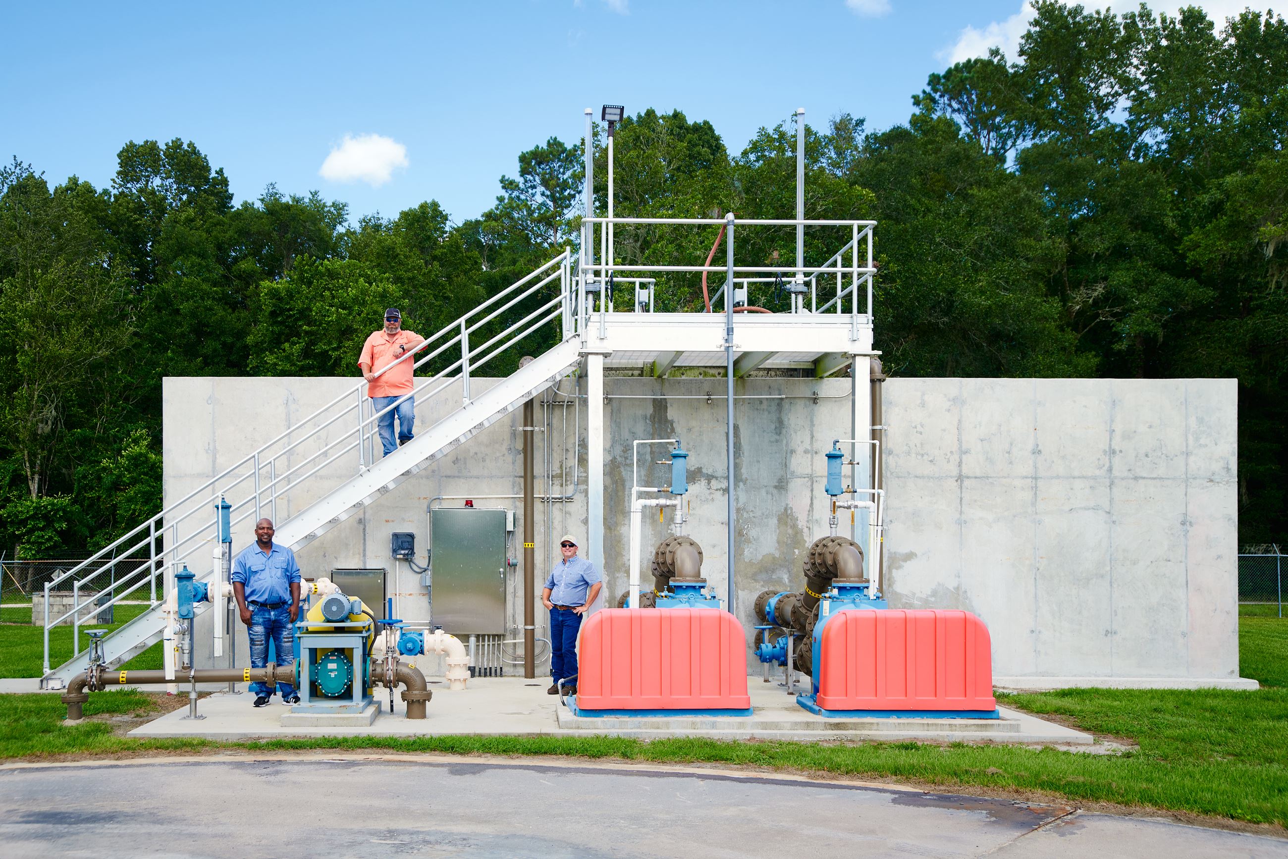Wastewater treatment plant with staff standing along it.