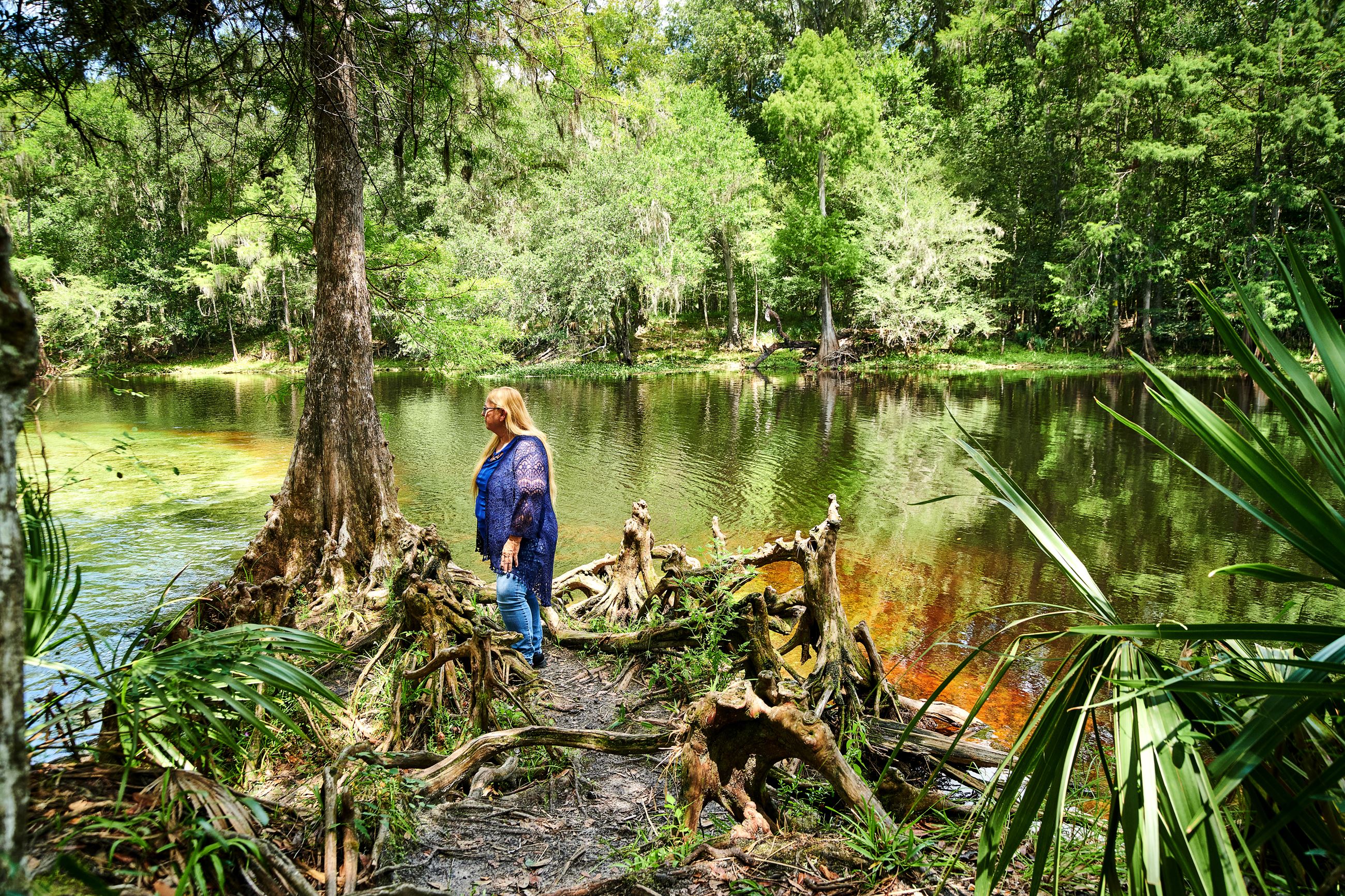 Woman by a cypress tree at the river.